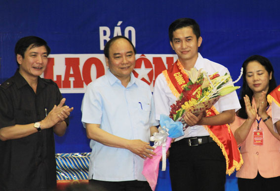 Thủ tướng Chính phủ Nguyễn Xuân Phúc tặng hoa cho đại diện công nhân lao động xuất sắc.